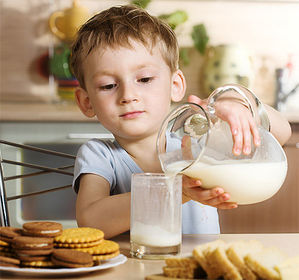 El niño se sirve leche