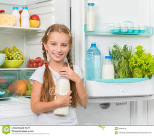 Ella toma la leche del refrigerador