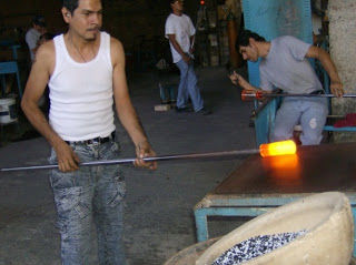 PASO 2: La masa caliente de vidrio se moldea sobre una placa de metal para comprimir los bordes y dar una forma semicilíndrica al vidrio.