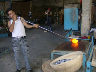 PASO 2: La masa caliente de vidrio se moldea sobre una placa de metal para comprimir los bordes y dar una forma semicilíndrica al vidrio.